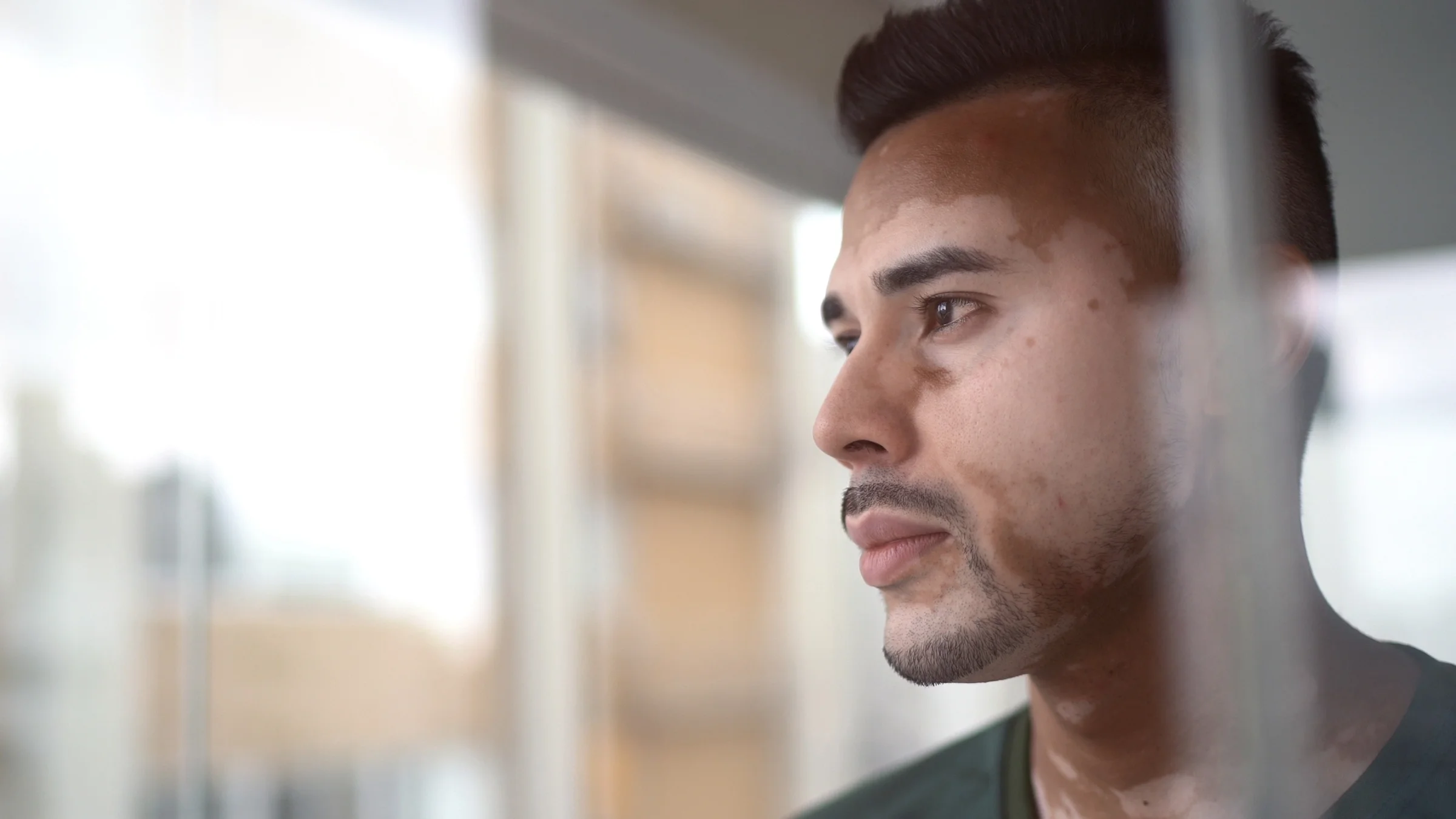 Close-up on a man's face as he looks out the window.