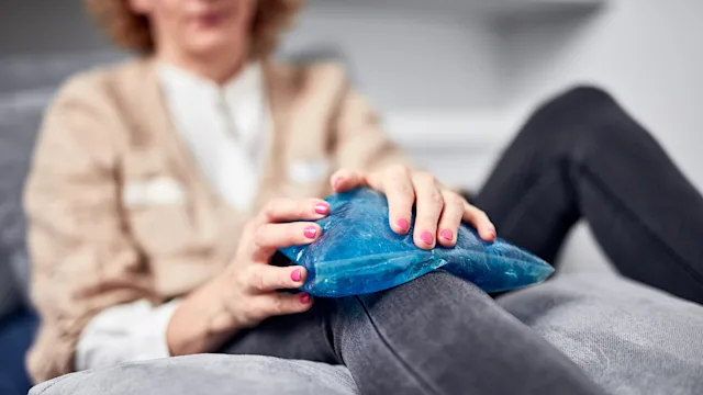 Menopause: woman using ice pack on knee 1364796428