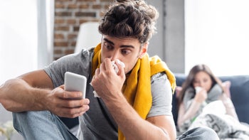 Cold symptoms: Timeline: sick blowing nose holding phone-1180776276