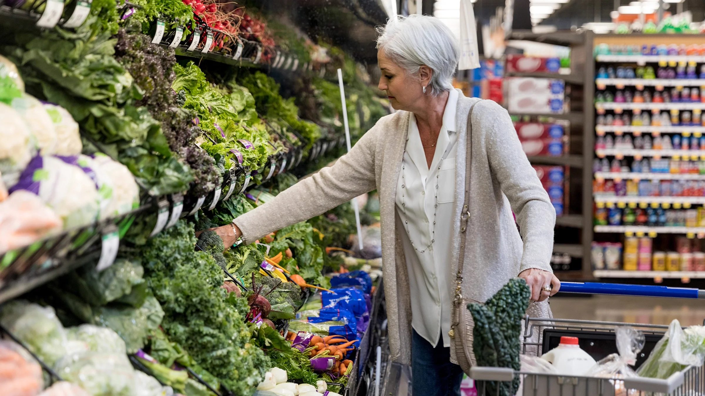 A woman shops for produce at a grocery store.