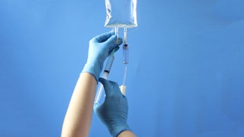 orencia: closeup hands with IV and syringe 1600984455