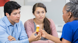 Doctor reviewing prescription with teenage patient and her father.
SDI Productions/E+ via Getty Images