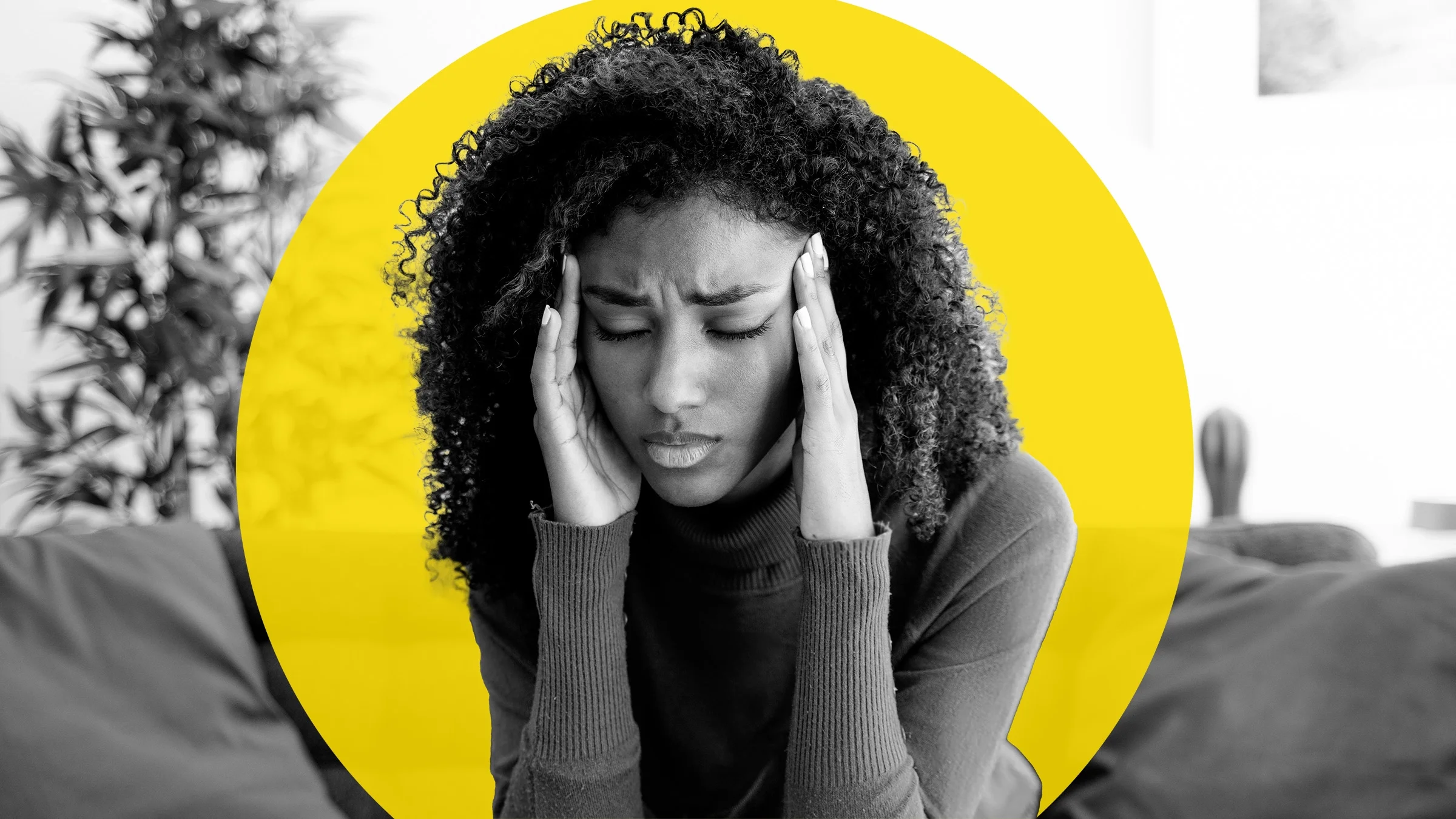 Black and white image of a young adult with a migraine. She is rubbing her temples and closing her eyes. There’s an added graphic yellow circle behind her.