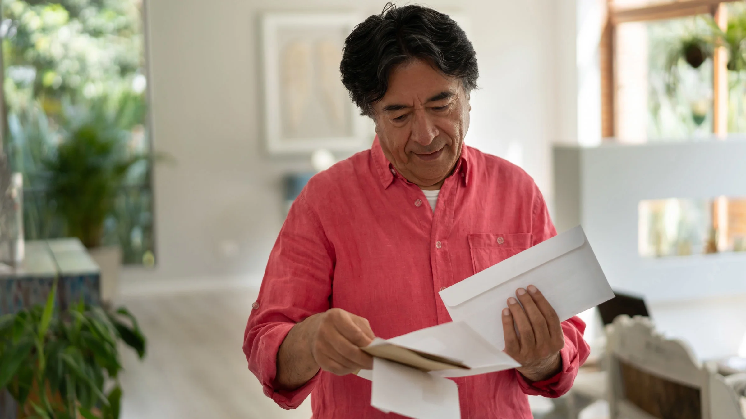 Senior man holding envelopes.