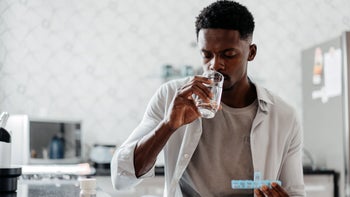 doxepin: man taking medication in kitchen 1455111136
