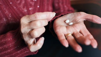 Medication Education: closeup white pills in hand 1160917037