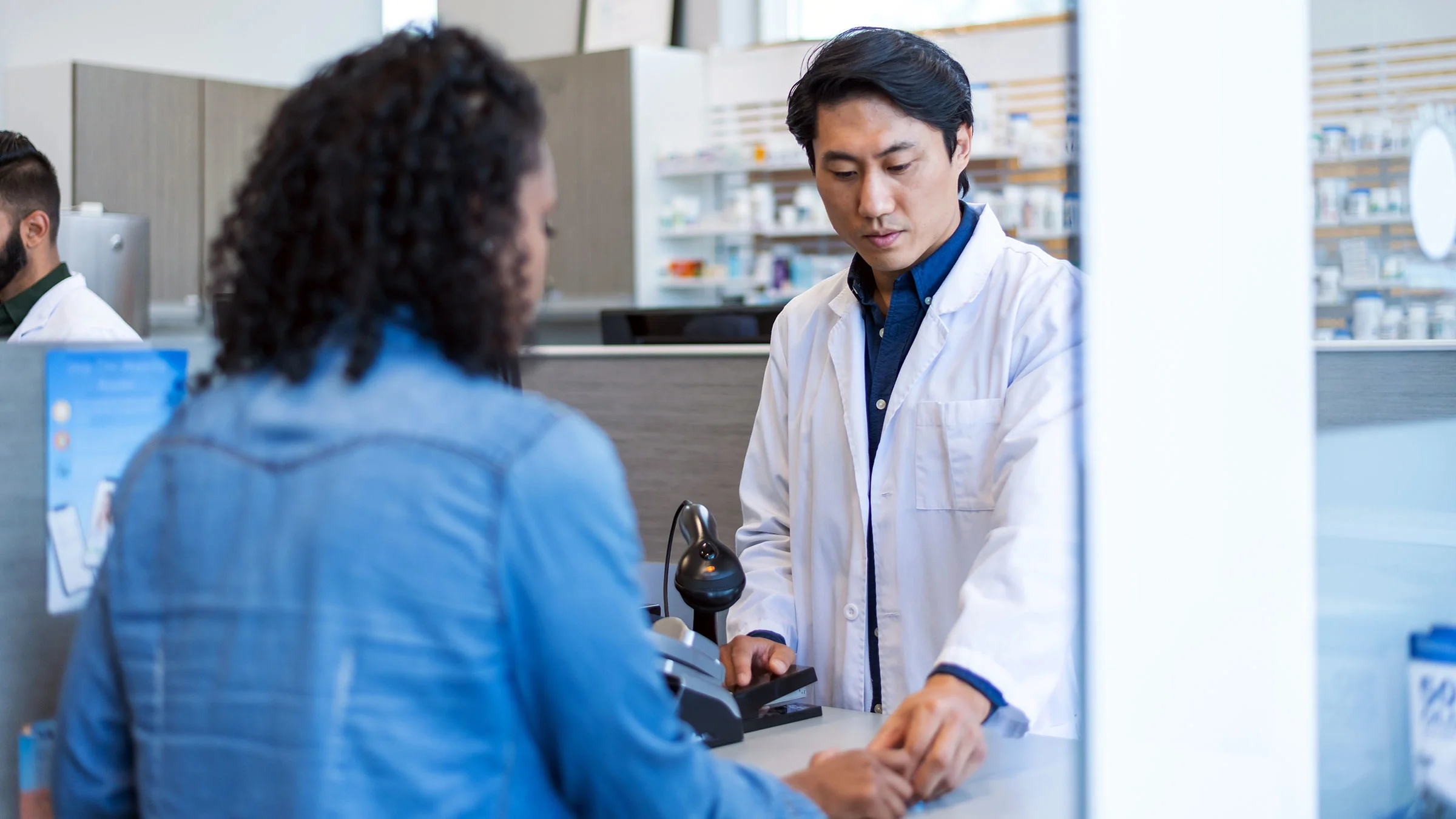 A pharmacist assists a customer with medication.