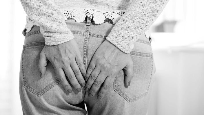 Close-up of a person holding their butt. It looks like they have the sudden urge to go to the bathroom.