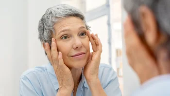 Health: Retinoids: woman looking at wrinkles in the mirror 1044153532