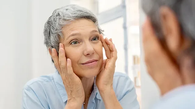 Health: Retinoids: woman looking at wrinkles in the mirror 1044153532