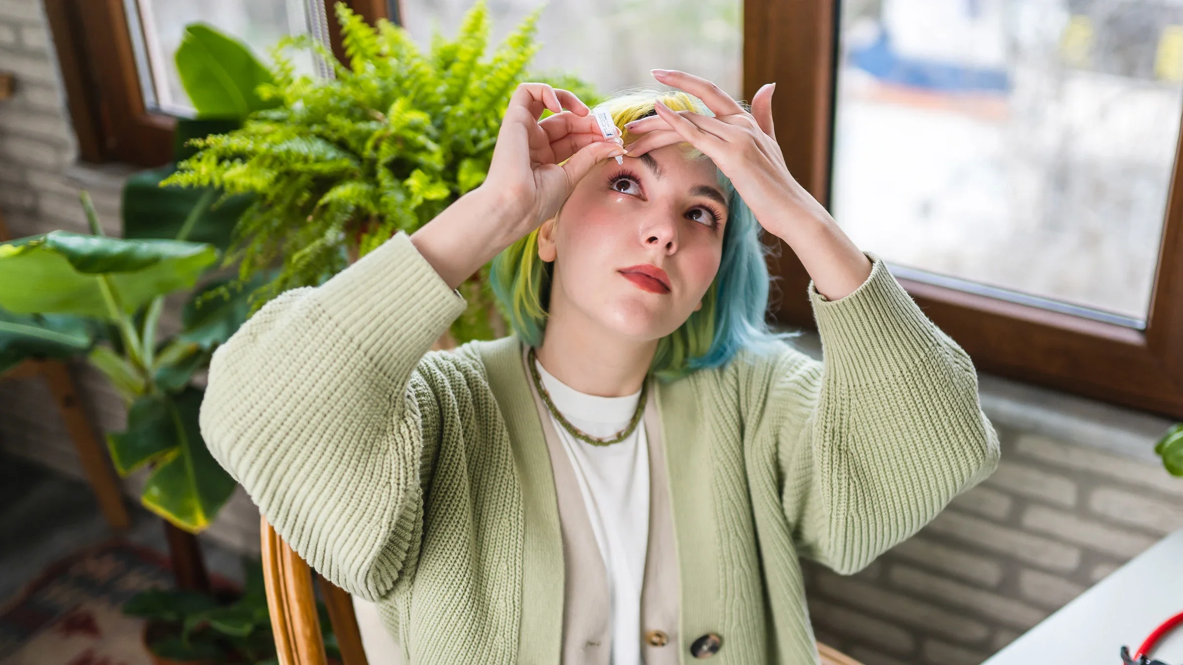 Dry eye: person with colorful hair applying eye drops-1383001042