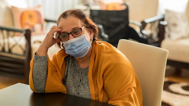 covid: senior woman wearing a mask 1289058995