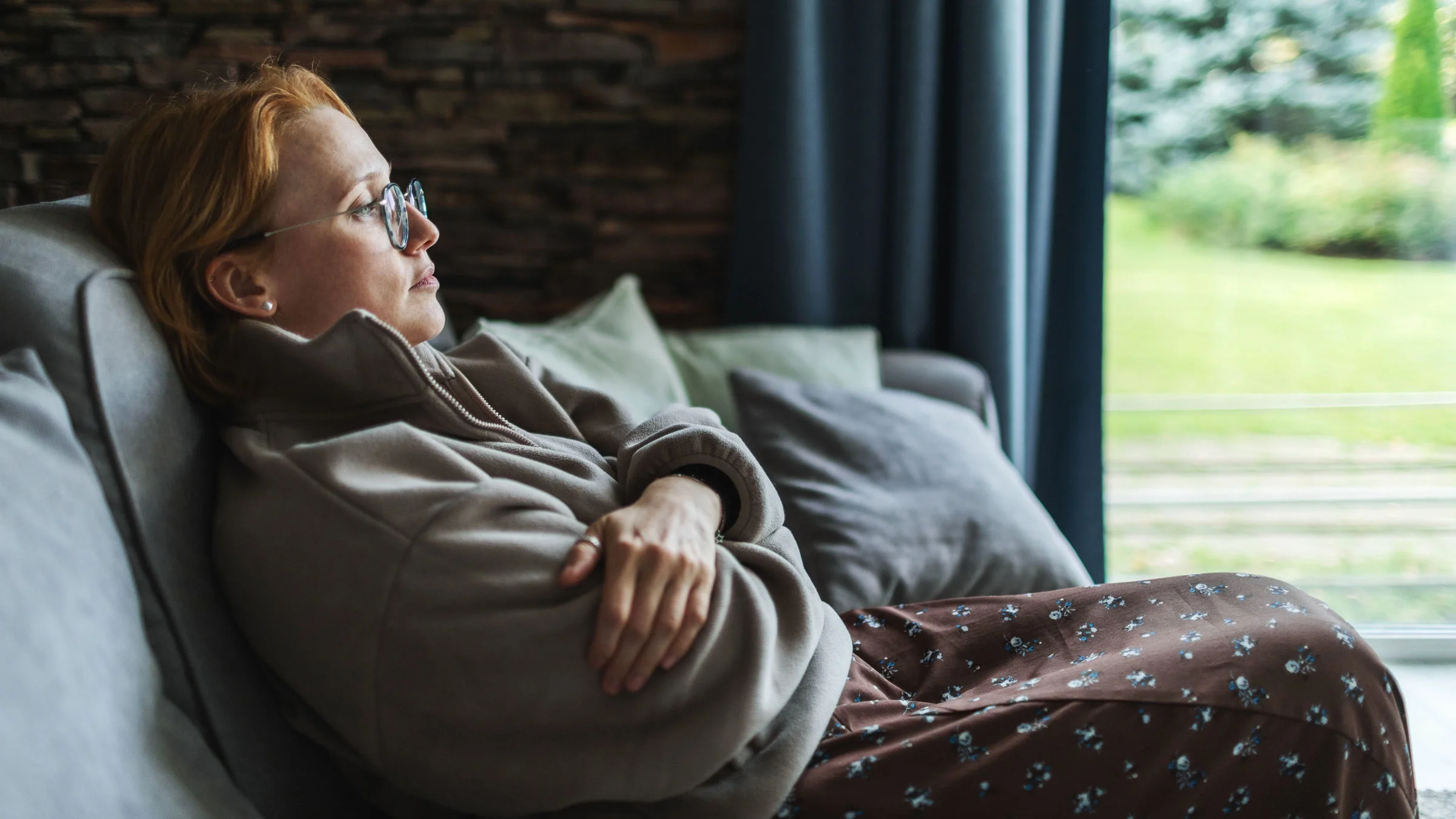 A person sitting on their couch, depressed.
