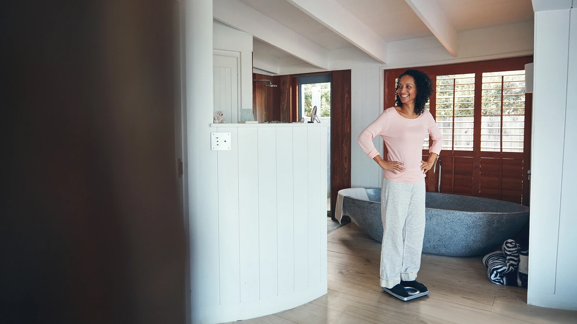 Woman weighing on a scale at home.