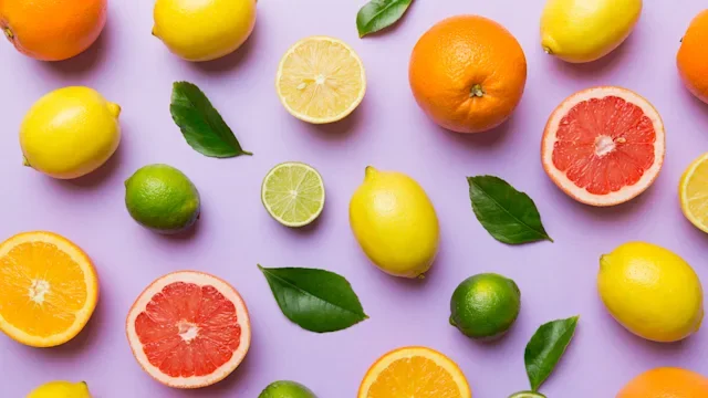 Diet nutrition: flat lay of citrus fruit on purple background 1402330770