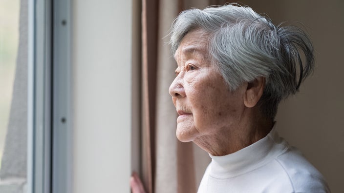 Older person starting out of their window.