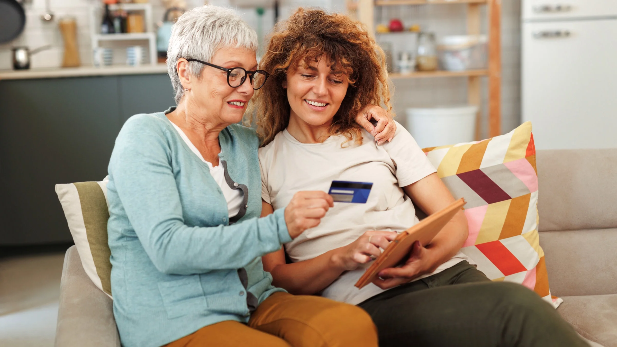 A grandparent and grandchild making an online credit card payment using a tablet.