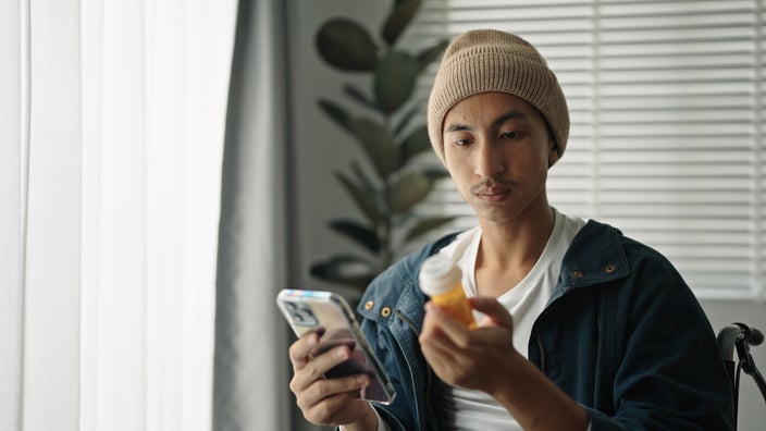 A man is reading a medication label.