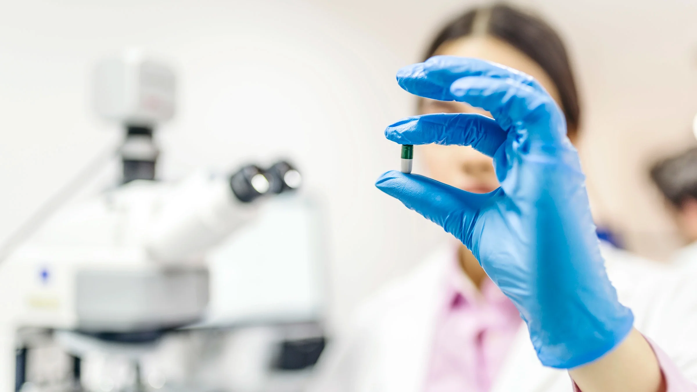 A scientist examining a pill.