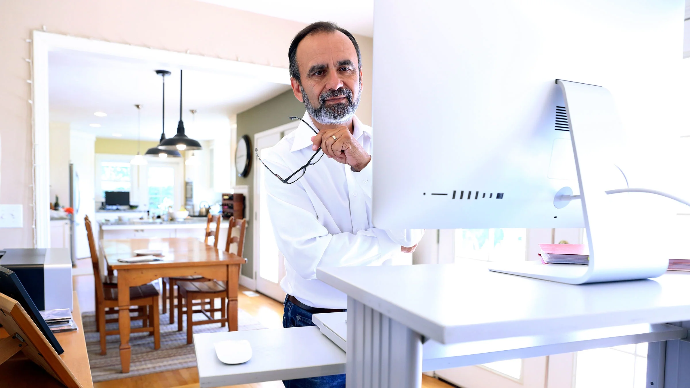 A man is working from home at a standing desk.