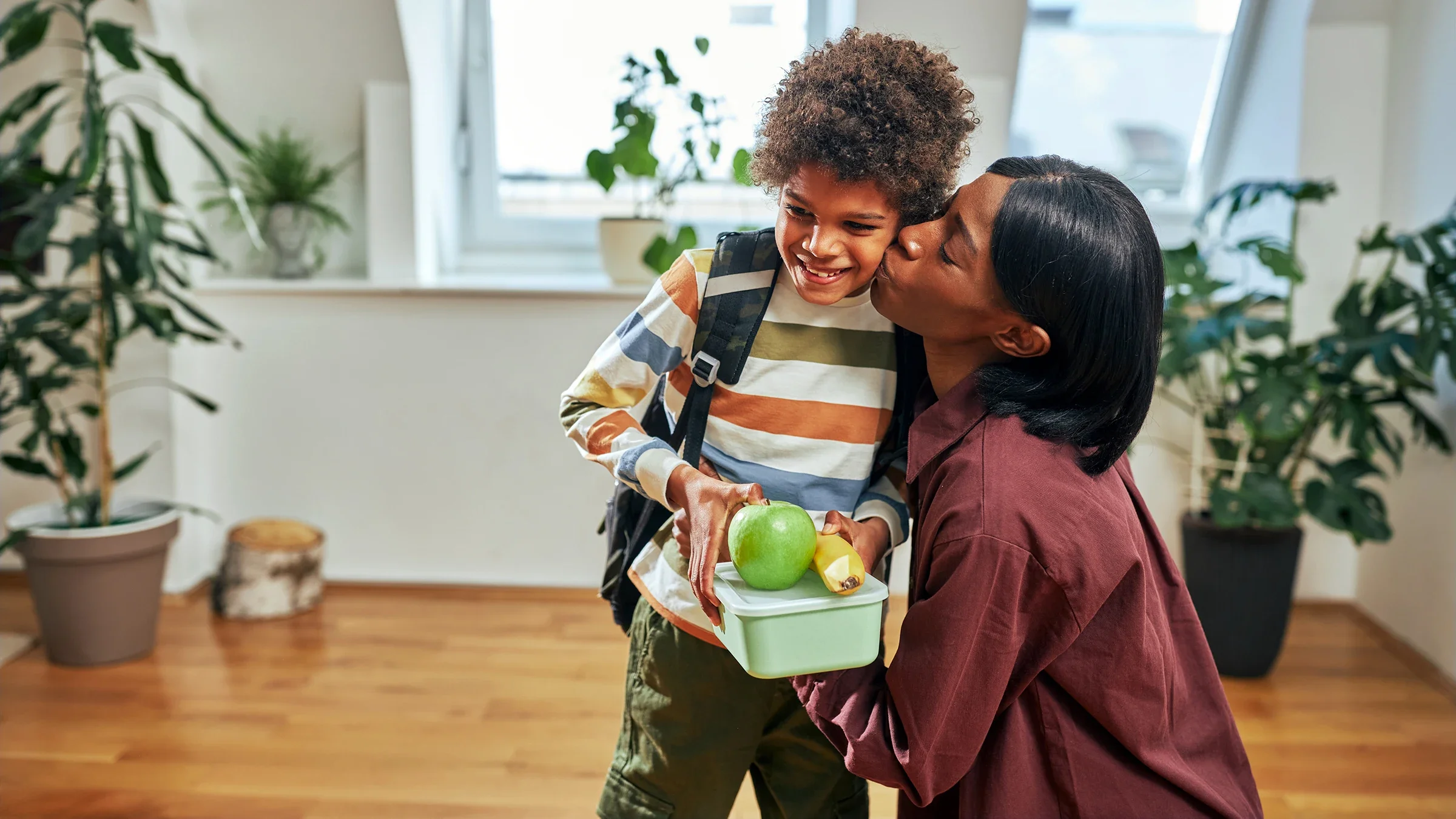 A mother kisses her son as she sends him off to school.
Dimensions/E+ via Getty Images