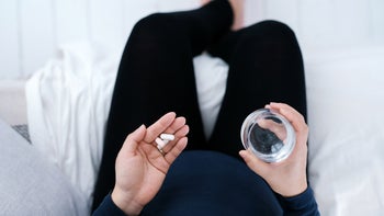 Providers: Self-prescribing: top view woman holding pills 1319469430