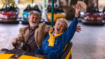 Health: Senior health: senior couple riding bumper cars-1190896608