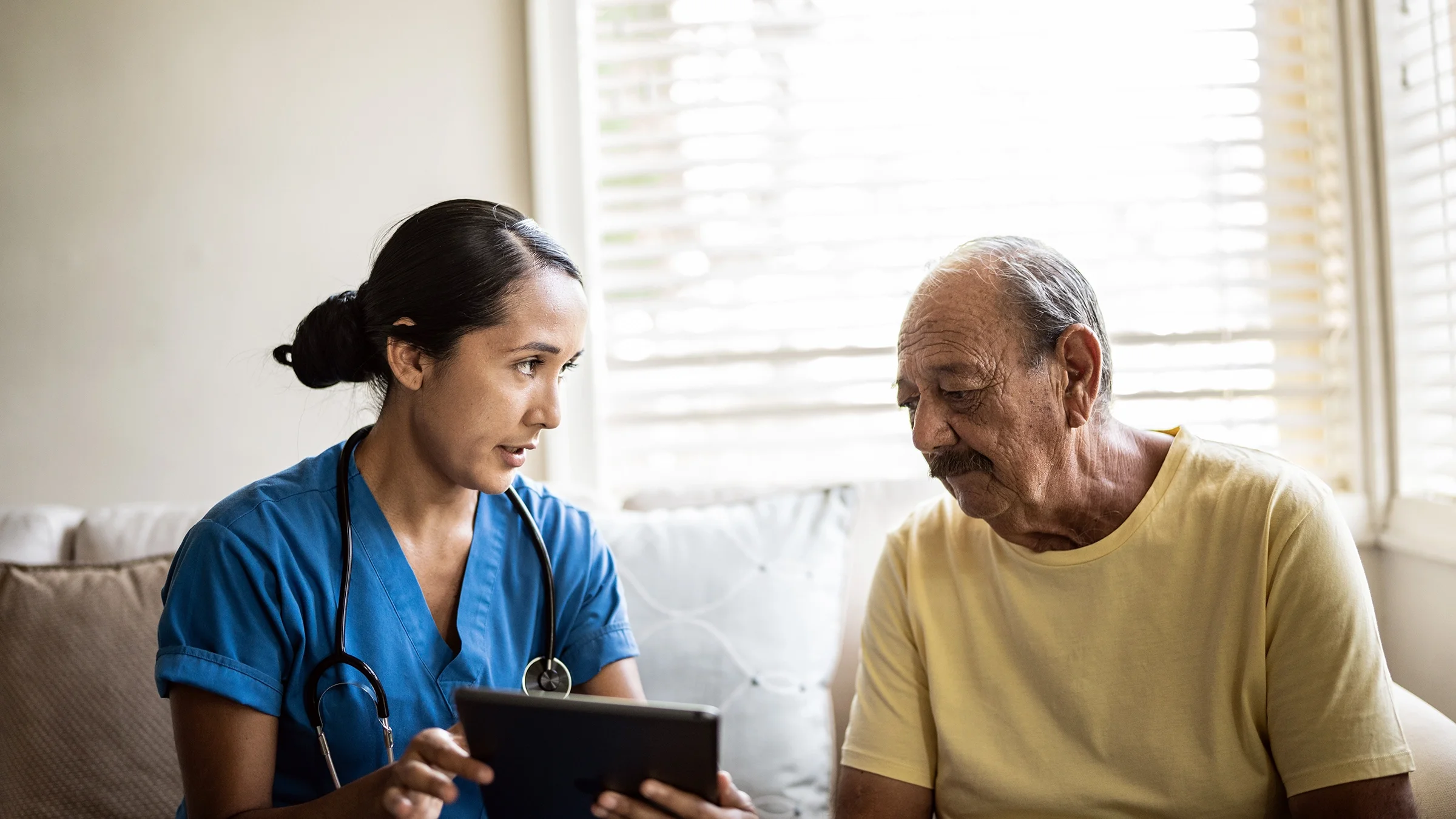 An older man talks with a medical professional.