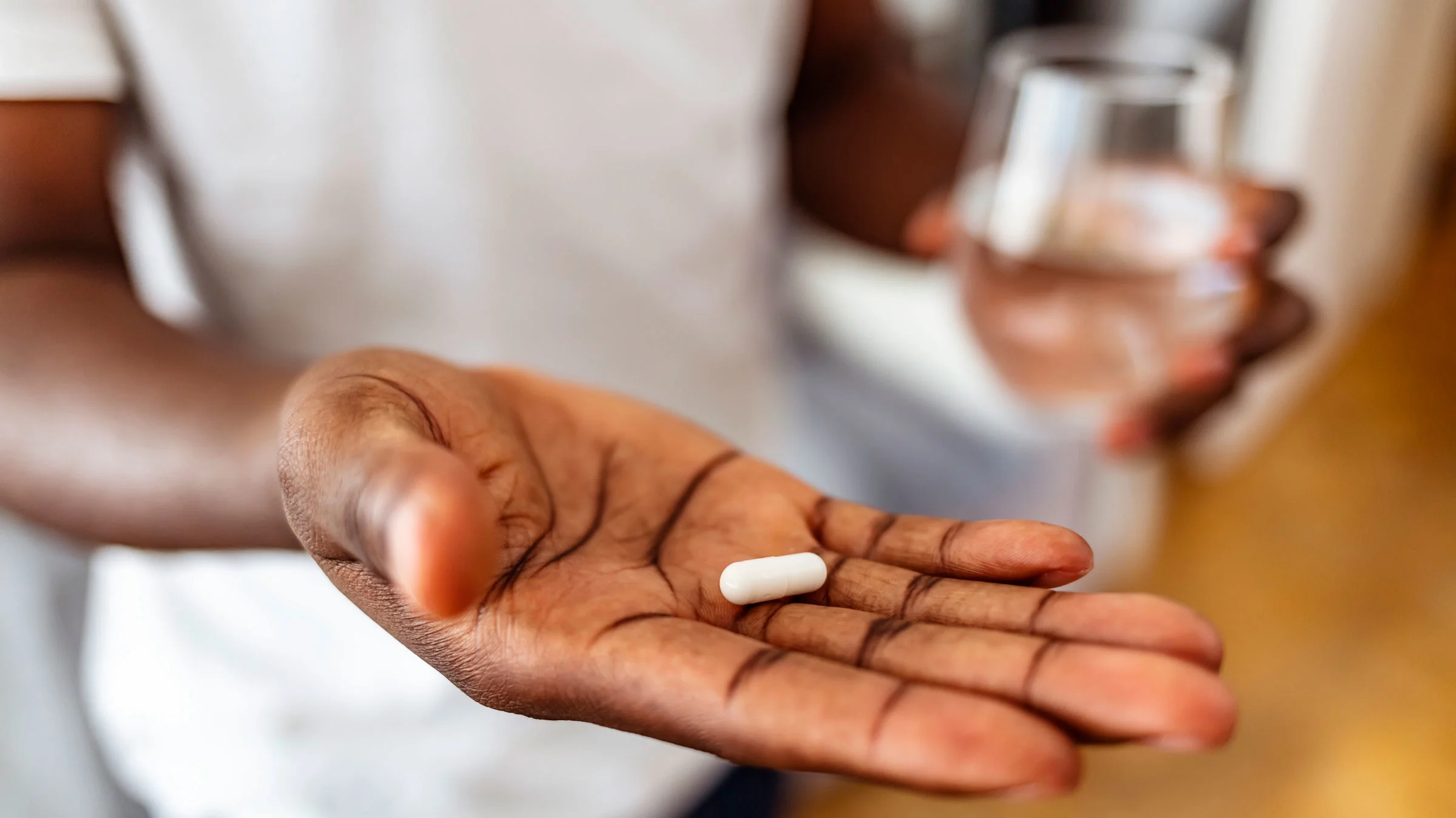 Close-up of pill in palm of hand.