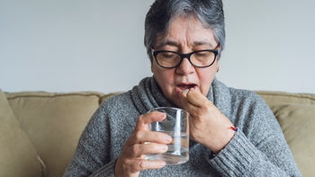 Pharmacy: woman taking medicine at home 1318743565