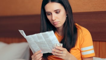 woman reading medication insert-1081247178