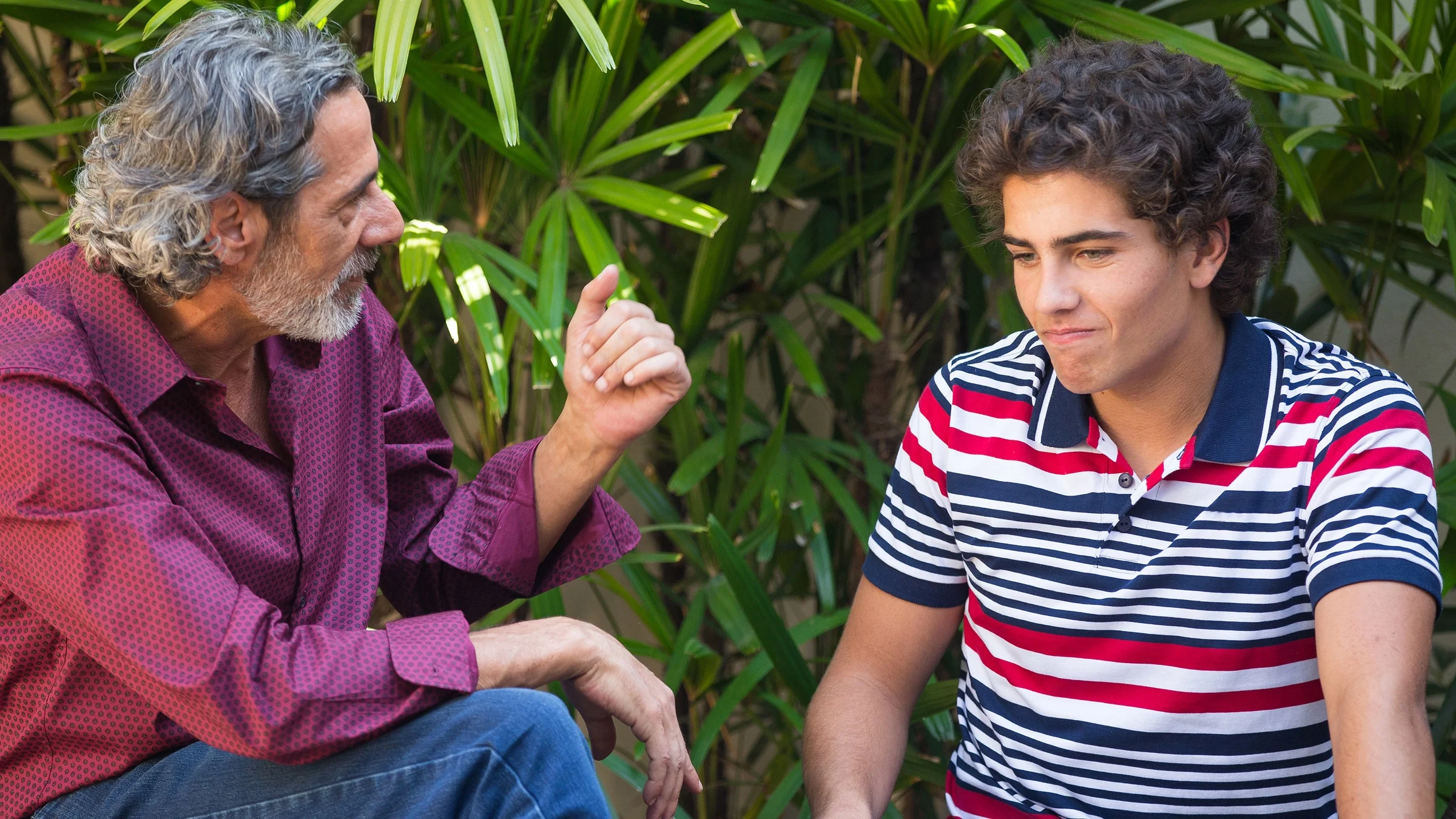 A parent and teenage child talking outside.