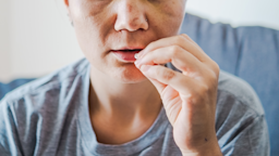 A man, in close-up, takes a pill by mouth.
Valentina Stankovic/E+ via Getty Images