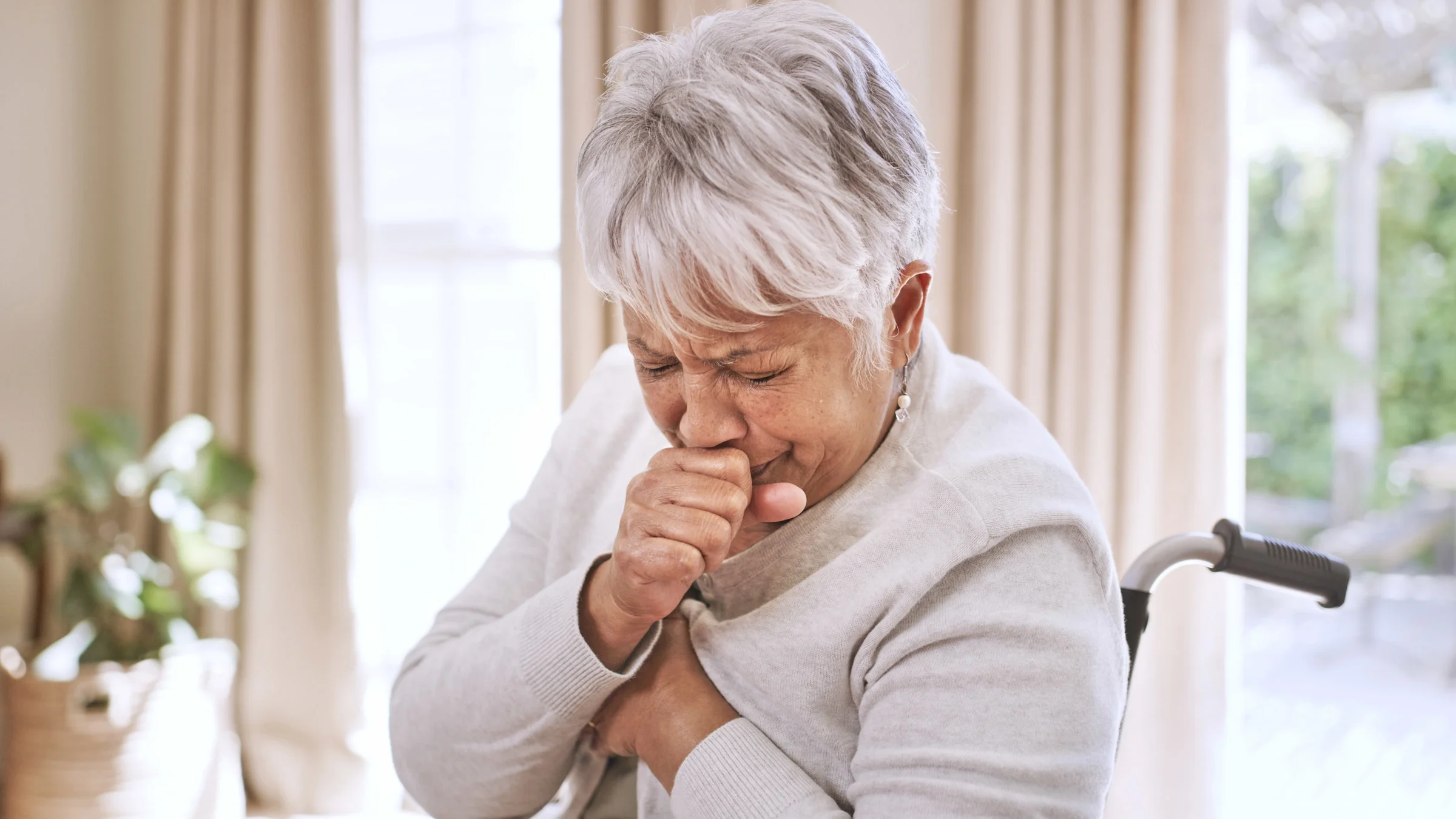 A senior adult coughing.