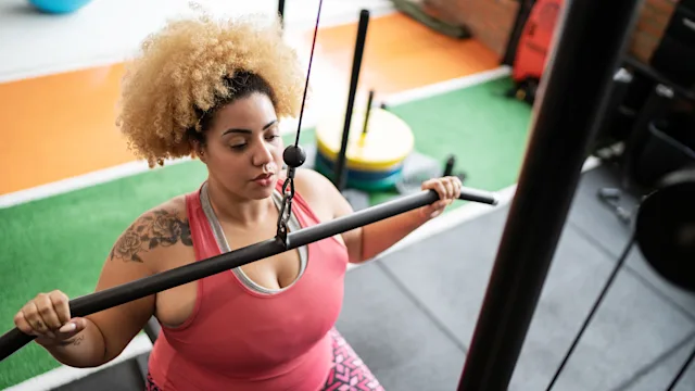 Movement Exercise: woman pulling weight at gym 1323057917