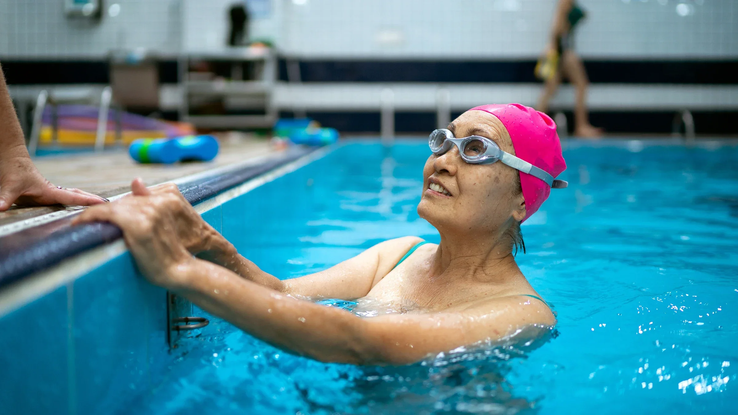 An older woman is taking a break from swimming laps in a pool.
FG Trade/E+ via Getty Images