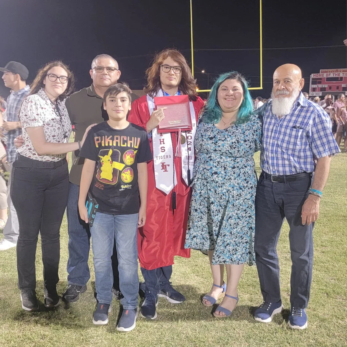 Claudia Perez-Favela is pictured standing on a football field with her family.