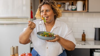 Womens-health: woman eating a salad 2194443401