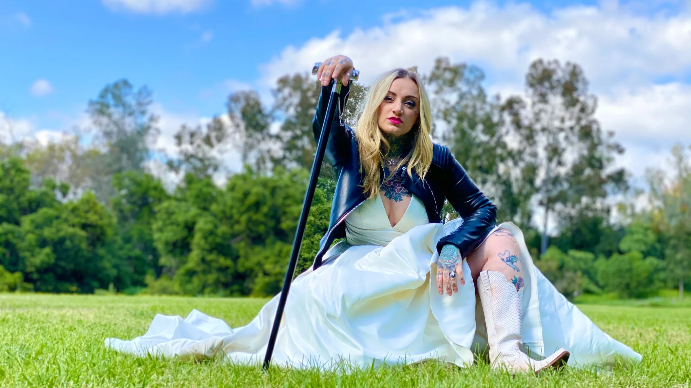 Brittany Quiroz sitting in a park holding her cane.