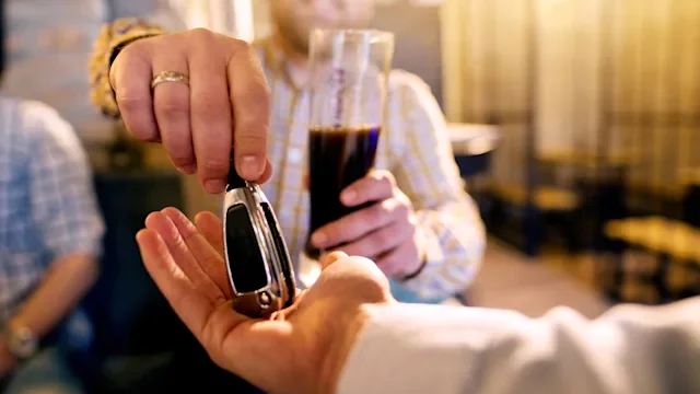 Alcohol: Helping drunk friend: handing keys to friend-996304868