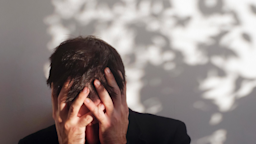A man in pain puts his face in his hands.
nemke/E+ via Getty Images 
