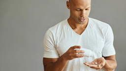 Man in white t-shirt takes pill. 
Drazen Zigic/iStock via Getty Images Plus
