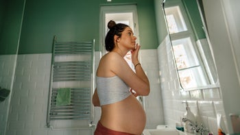 pregnancy: pregnant woman applying face mosturizer 1252901051