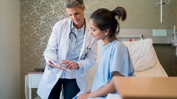 gynecology: woman speaking to medical professional post surgery 904795070