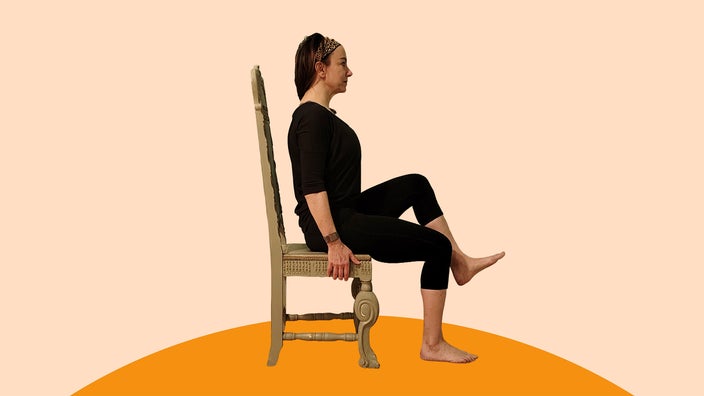 A woman does a seated march exercise.