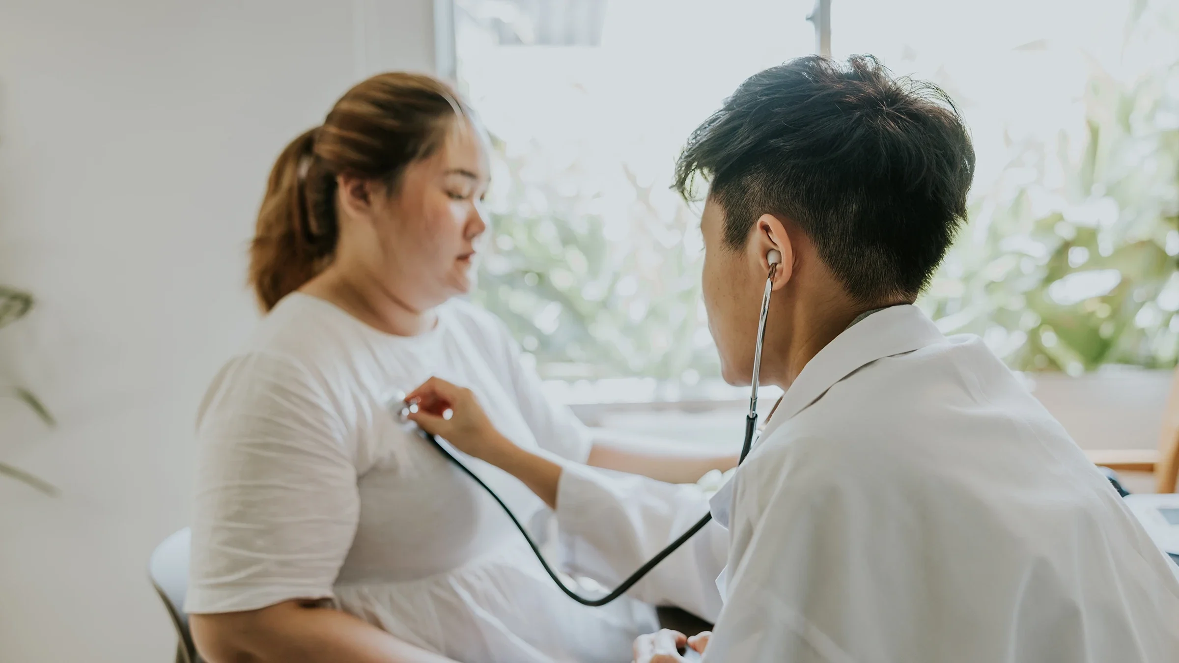 A doctor listens to a patient’s heartbeat.