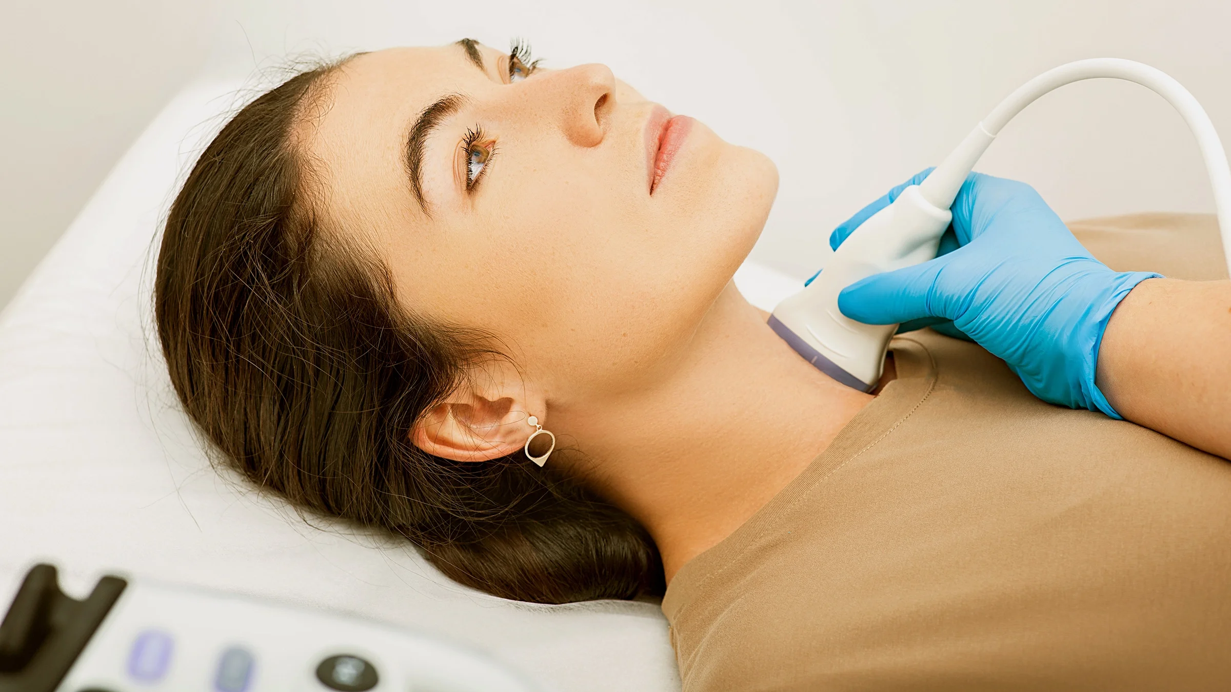 A woman is getting a thyroid ultrasound.