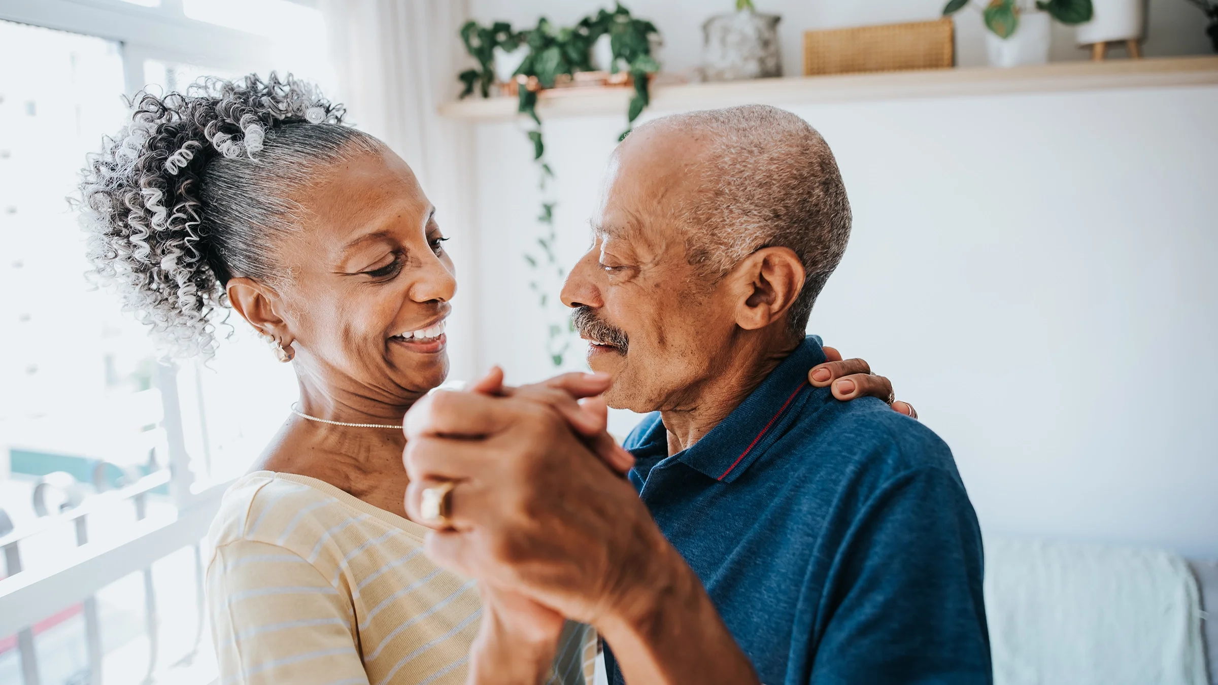 A couple dance in their living room.