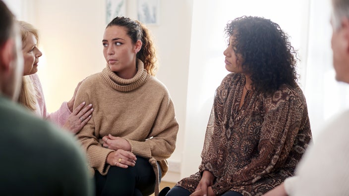 A woman has a discussion with a support group.