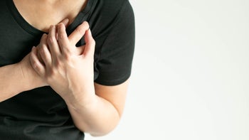 woman clutching heart pain-1217316737
